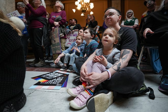 Alex Adams, her daughter, Ada Adams, 3, and their family listen as a drag queen reads a book during a Rally to Protect Trans Youth organized by the ACLU of Indiana on Saturday, April 1, 2023, at the Statehouse in Indianapolis.