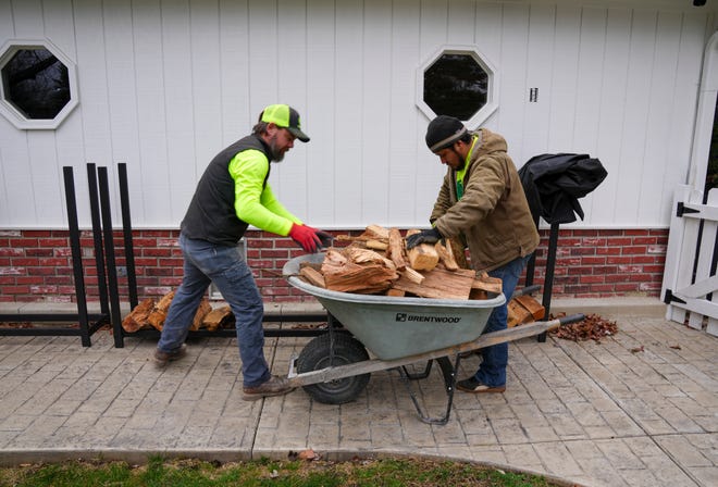 Dustin Brown (left) and Henry Lopez deliver three ricks of kiln-dried wood on Thursday, Jan. 4, 2024, in Zionsville. A rick is typically four by eight feet of stacked wood, and three ricks comprise a cord, a term usually more familiar on the West Coast.