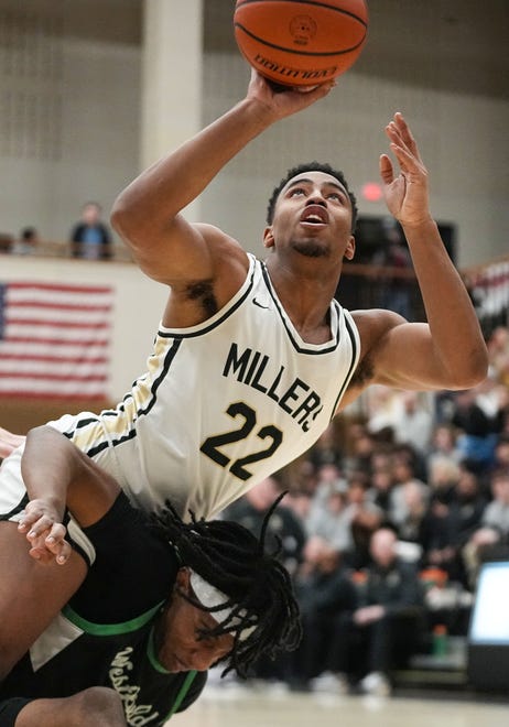 Noblesville Millers forward Aiden Brewer (22) attempts to shoot the ball while falling over Westfield Shamrocks forward Durante Morton (33) on Wednesday, Jan. 17, 2024, during the game at Noblesville High School in Noblesville. The Westfield Shamrocks defeated the Noblesville Millers, 58-54.