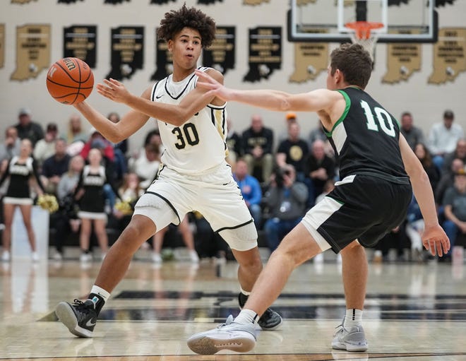Noblesville Millers guard Baron Walker (30) passes the ball against Westfield Shamrocks Will Harvey (10) on Wednesday, Jan. 17, 2024, during the game at Noblesville High School in Noblesville. The Westfield Shamrocks defeated the Noblesville Millers, 58-54.