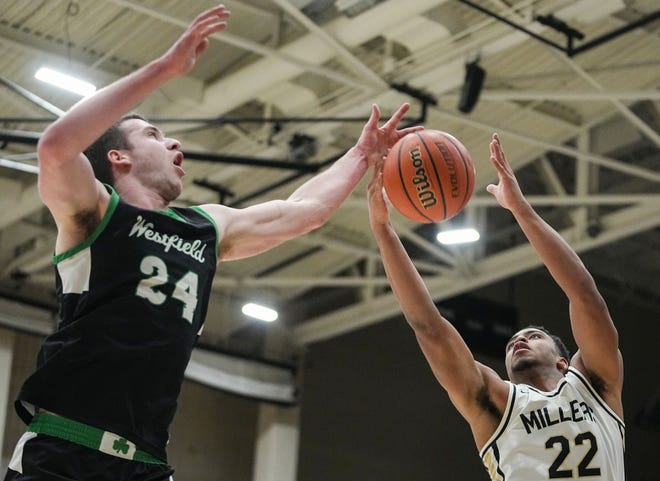 Noblesville Millers forward Aiden Brewer (22) and Westfield Shamrocks forward Nic Book (24) attempt to recover a rebound Wednesday, Jan. 17, 2024, during the game at Noblesville High School in Noblesville. The Westfield Shamrocks defeated the Noblesville Millers, 58-54.