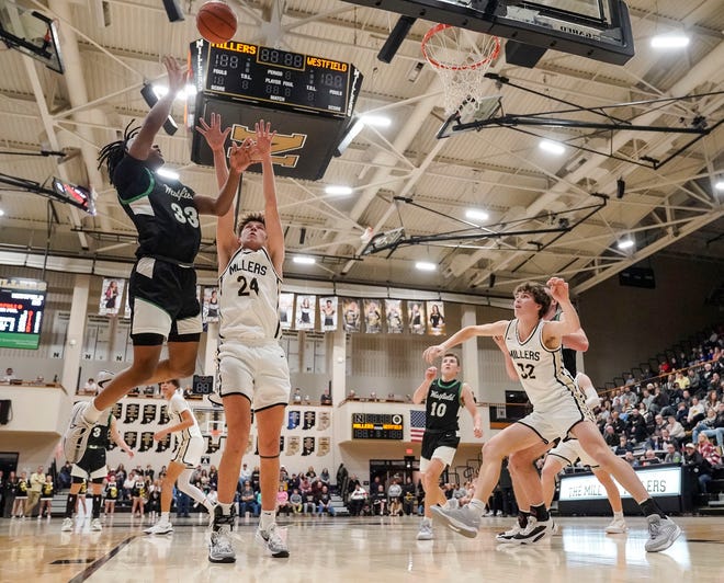 Westfield Shamrocks forward Durante Morton (33) goes in for a lay-up against Noblesville Millers forward Hunter Walston (24) on Wednesday, Jan. 17, 2024, during the game at Noblesville High School in Noblesville. The Westfield Shamrocks defeated the Noblesville Millers, 58-54.