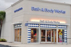 An employee with a face mask and shield cleans the door of Bath & Body Works store on July 21, 2020 in Pembroke Pines, Florida.